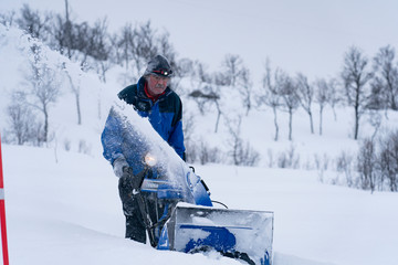 facility manager riding a snowblower in a heavy blizzard in northern Norway