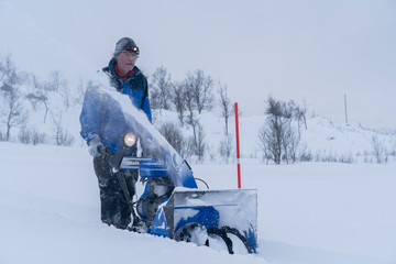 facility manager riding a snowblower in a heavy blizzard in northern Norway