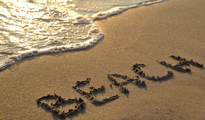 Beach written on sand.