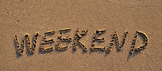 Fototapeta premium Weekend written on sand.