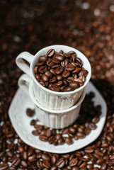 A porcelain white cup full of beans of coffee