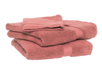 Towels isolated. Closeup of a stack or pile of old pink soft terry bath towels isolated on a white background.