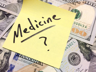 American cash money and yellow paper note with text Medicine with question mark