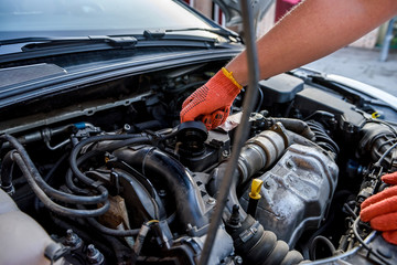 Fototapeta na wymiar Human hands examining car engine in protective gloves close up