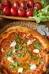 High angle view of Italian pizza with cheese and cherry tomatoes on the table