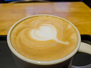 Close up shot of cup of hot latte coffee with a heart shape art