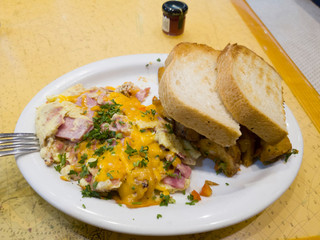 Close up shot of a plate of fried egg and ham with bread