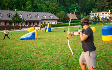 Teenage boy playing archery tag during summer