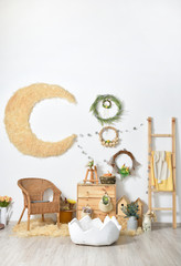 Rustic-style kids room with Easter decorations against a white wall, with wooden furniture and toys and flowers.
