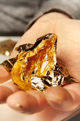 Artwork of gilding - sheet of creased gold metal plate in hands