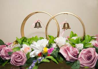 Large symbolic decorative wedding rings on a background of flowers.
