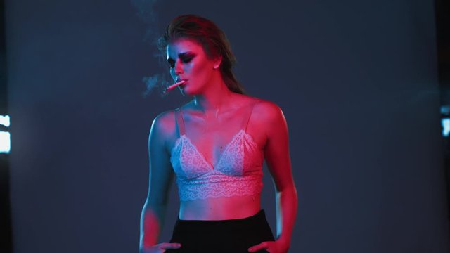 young undressed ginger sexy girl smoking three cigarettes at once, red and blue neon light, red haired girl in underwear or lingerie with fashion make up and hair style