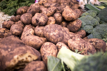 Fresh organic potatoes and broccoli at Borough Market on counter.