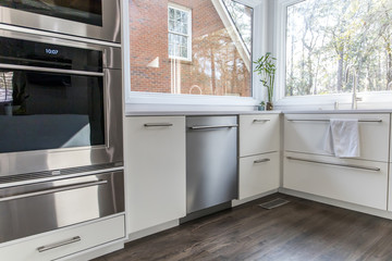 spacious large modern white kitchen recently updated with high end appliannces, wood floors, picture windows, white cabinets and wood beams and a great view of the backyard