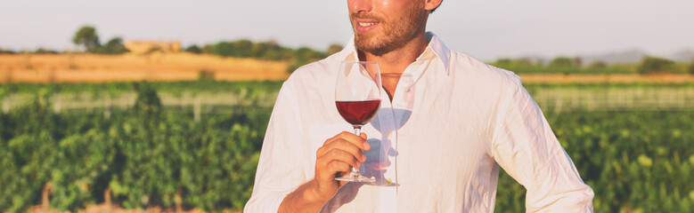Wine tasting course outdoor at winery vineyard panoramic banner. Man holding glass of red wine at New Zealand farm tour summer vacation panorama.