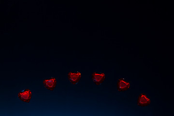 red heart shaped gemstones on black background