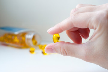 hand and omega-3 pills. virus protection