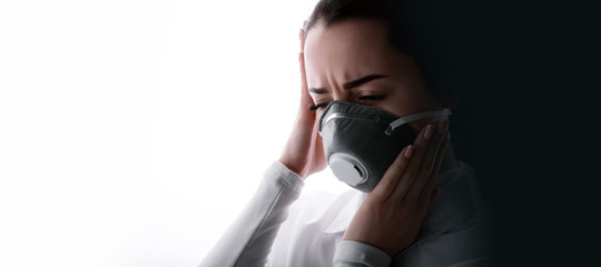 Portrait of young sad female doctor suffering from severe headache, pressing her fingers to temples. Woman in protective respirator. Free space for text. White background. Healthcare concept.