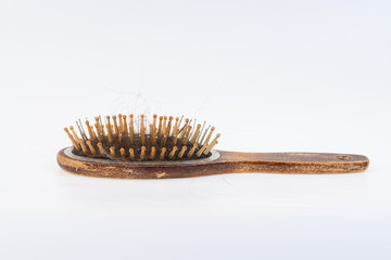 Health problems that cause hair loss and hair loss. Women's wooden brush with the rest of the hair on a light surface