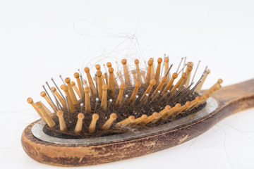 Health problems that cause hair loss and hair loss. Women's wooden brush with the rest of the hair on a light surface