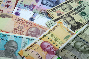 Assorted American and asian paper money background. Mix of American, Chinese and Indian colorful banknotes close up.