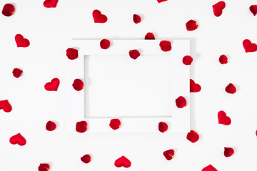 Elegant composition for Valentine's Day. Empty paper blank, red hearts, rose petals on white background. Valentine day, 8th march, Mother day background. Love concept. Flat lay, top view, copy space