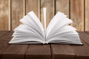 Open book on an old wooden table.
