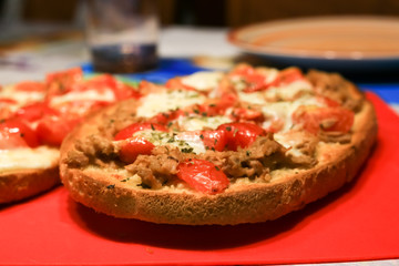 treviso, italy, 01/03/2020 , Bruschetta with cheese, tomatoes and tuna fish served as dinner in an italian house.