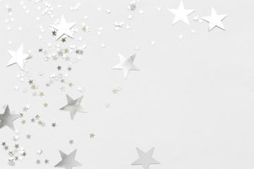 Silver confetti and stars and sparkles on a light background. Top view, flat lay. Copy text. holiday background. For Christmas, New Year, Valentine's Day