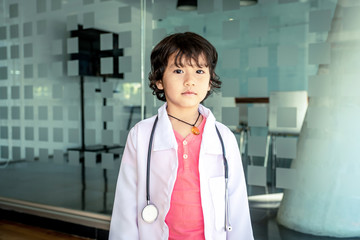 Photo of kid doctor with stethoscope working in the office