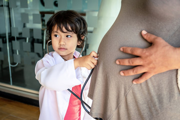 Photo of kid doctor and stethoscope with pregnant mother in the office