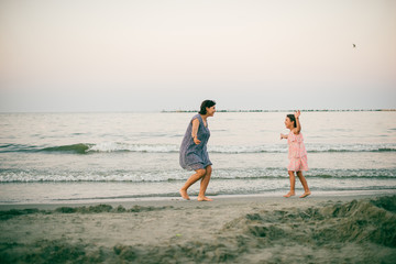 Mother and daughter enjoy together at sunet on the beach
