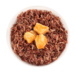 Delicious brown rice in bowl isolated on white, top view