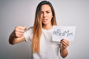 Naklejka premium Young beautiful woman holding paper with best mom message celebrating mothers day annoyed and frustrated shouting with anger, crazy and yelling with raised hand, anger concept