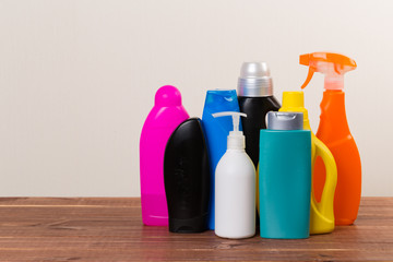 Cleaning product plastic container for house clean on wooden table and gray background . household chemicals