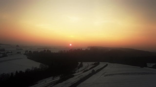 Crane shot of snow covered landscape during sunset