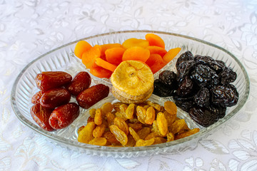 Jewish holiday Tu Bishvat in Israel: Traditional jewish food, Dried fruits. Apricots, Prunes, Dates and Raisins in a glass tray