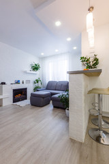 Spacious villa interior with cement wall effect, fireplace and tv