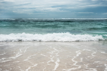 Fototapeta na wymiar Sea beach surf waves turquoise water blue dramatic sky landscape 