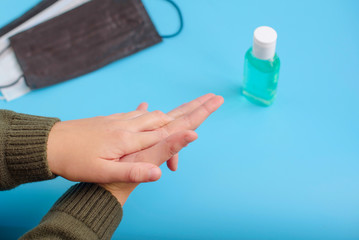 child applying gel sanitizer on his hands, protection against microbes and viruses