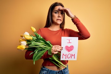 Beautiful woman celebrating mothers day holding love mom message and bouquet of tulips stressed...