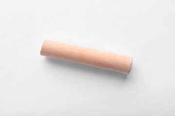 Piece of orange chalk isolated on white, top view