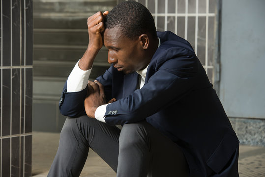 Portrait Of A Sad Depressed Young Man Sitting Outside