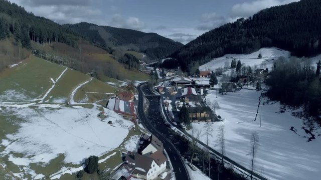 Drone footage of town in valley amidst mountains during winter, Kniebis, Black Forest, Germany