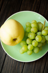 Green apple and grapes on dark wooden table flat lay