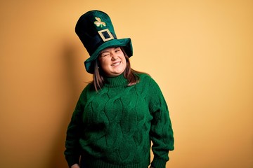 Young beautiful plus size woman wearing green hat with clover celebrating saint patricks day...
