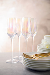 Set of clean dishes and glasses on light grey table