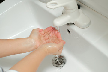 感染症予防のうがいの為に手に水をくむ女性