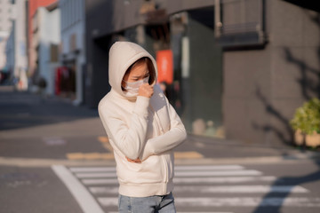 Fototapeta premium 屋外でマスクをしている若い女性
