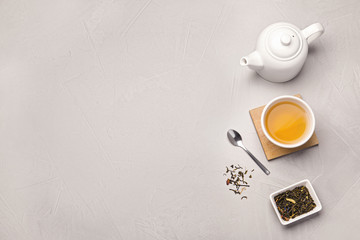 Obraz na płótnie Canvas Flat lay composition with cup of hot aromatic tea on light grey table. Space for text